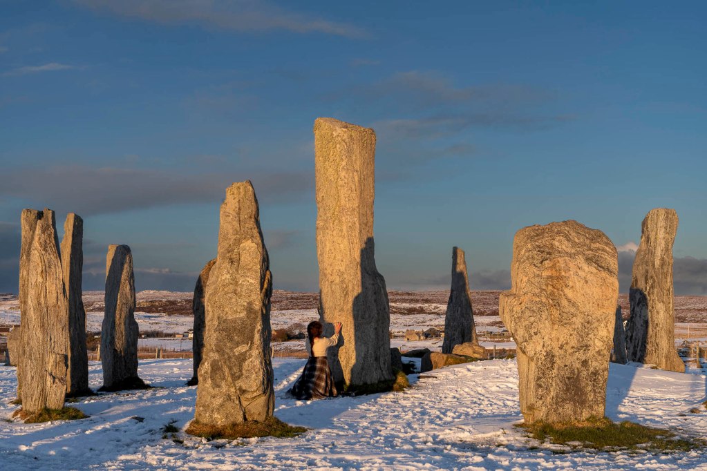 Thumbnail image of the Callanish Stones in Scotland, with woman touching the stones for Rock category