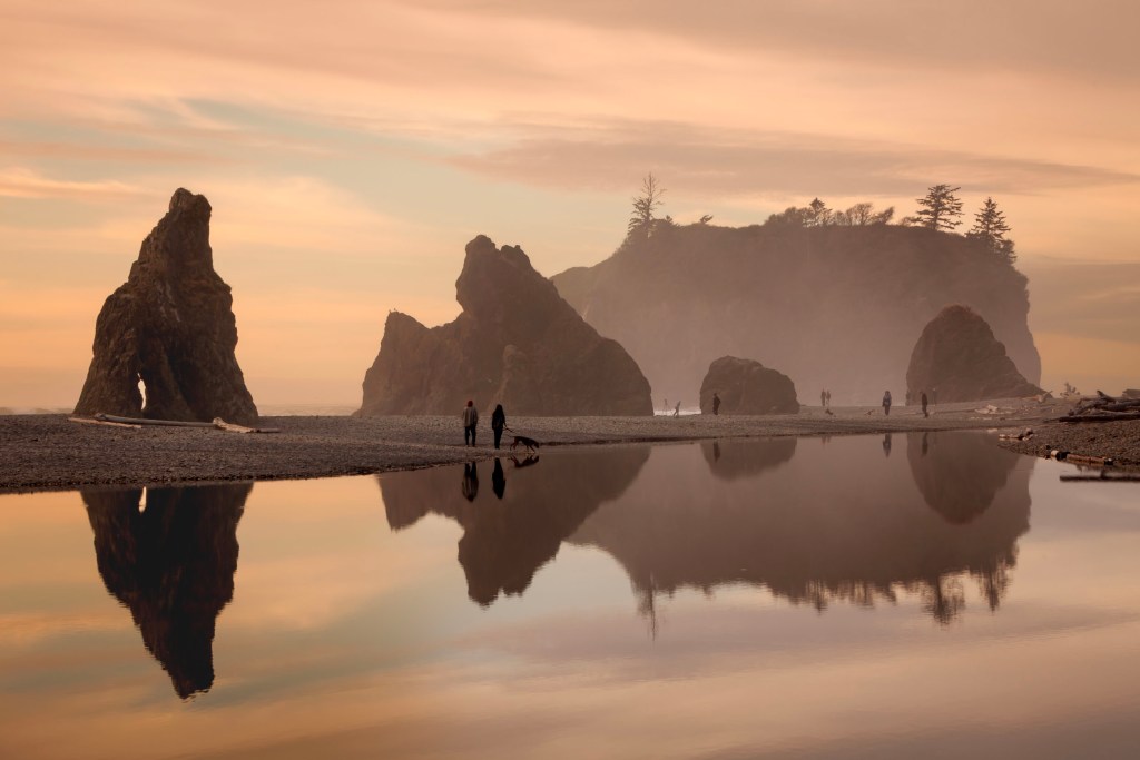 A sultry light mist highlights the sunset colors of peach blue and light purple with the sea stacks reflecting in the lagoon at Ruby Beach in Olympic National Park, Washigton State