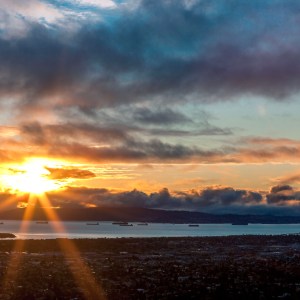 Voltage like sun rays stream through a stormy sky at sunset over San Francisco CA