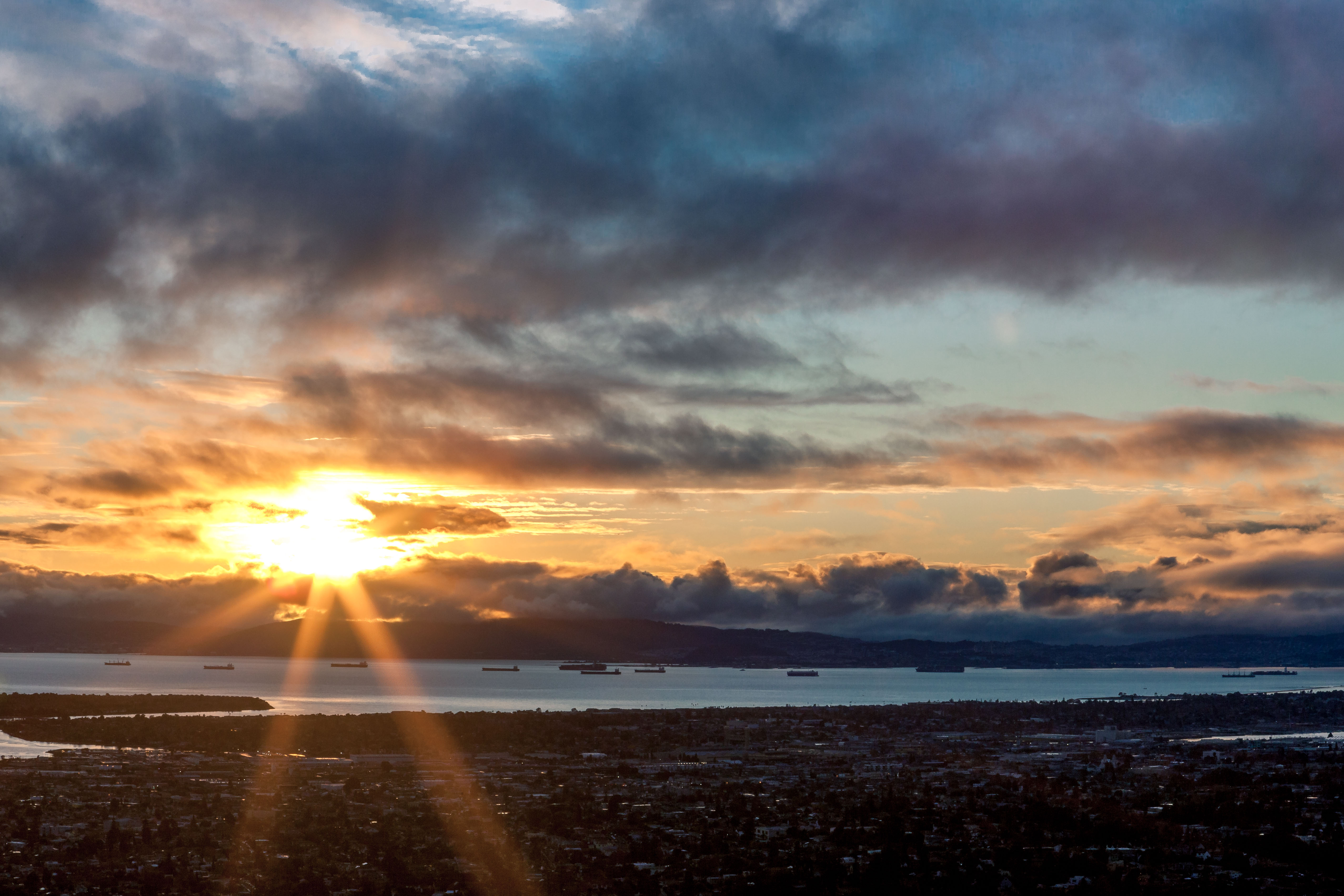 Voltage like sun rays stream through a stormy sky at sunset over San Francisco CA