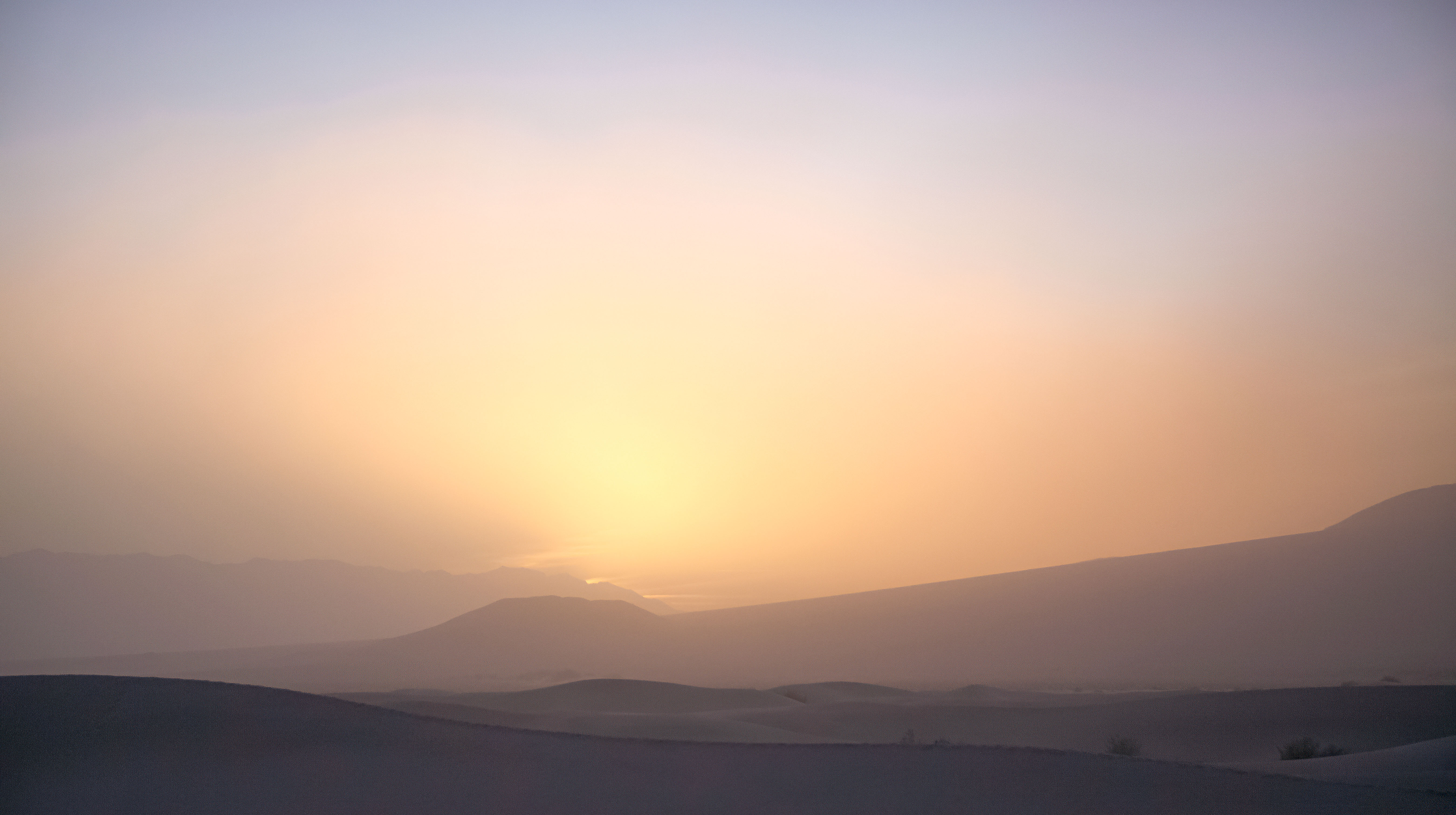 Sand fills the air creating a mystical sunrise at Mesquite Sand Dunes in Death Valley National Park