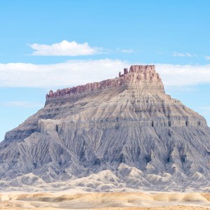 This imposing and beautiful lone butte east of Capitol Reef National Park, engages one in wonder at it's soft desert colors and strong badlands from the erosion of time.