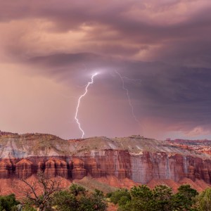 A lightning storm at Capitol Reef National Park grazes the distant cliffs while I, and others watch safely and capture many lightning strikes in their awesome fury.