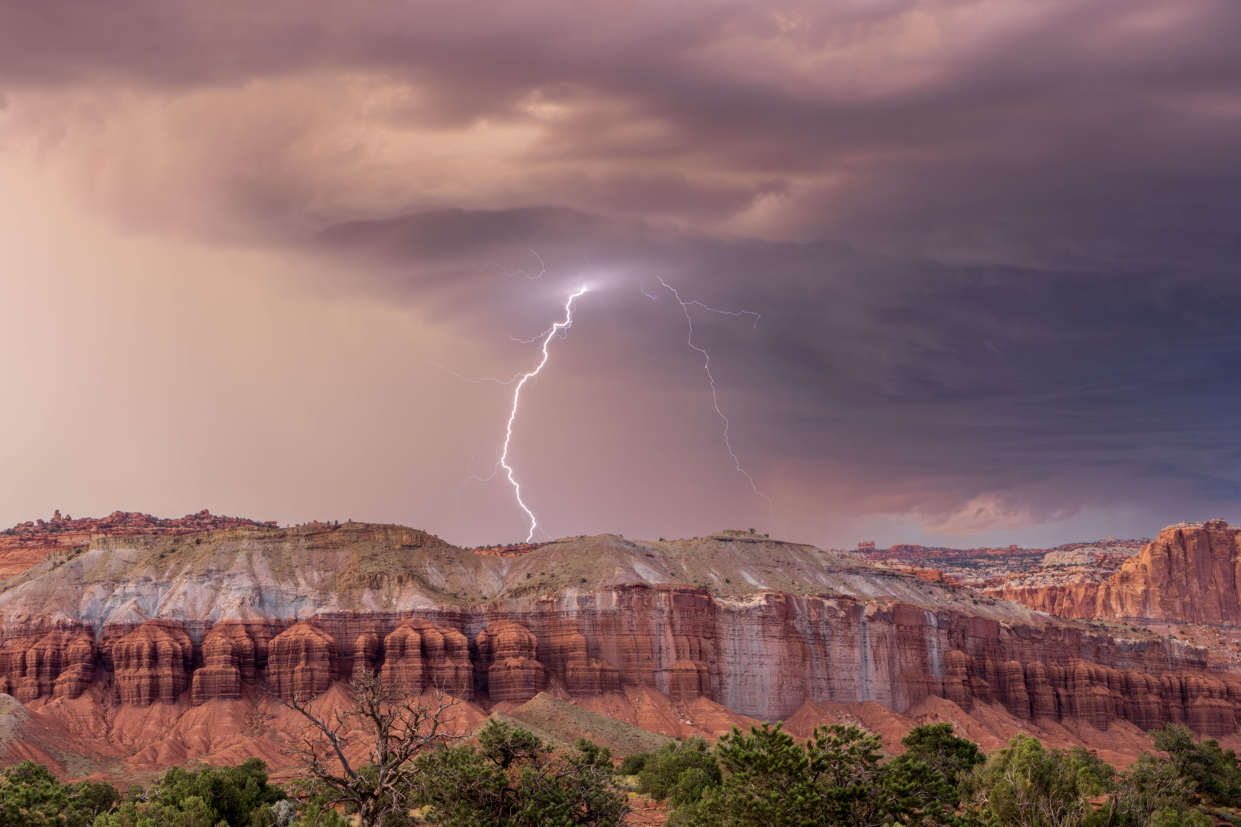 A lightning storm at Capitol Reef National Park grazes the distant cliffs while I, and others watch safely and capture many lightning strikes in their awesome fury.